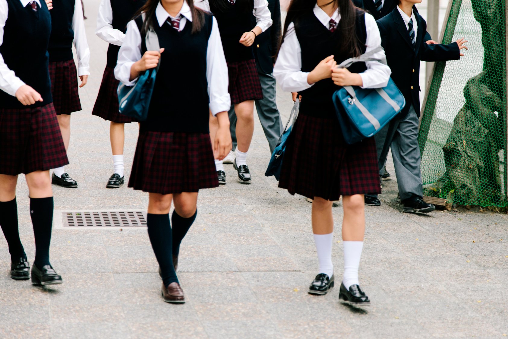 Japanese high school. School children walk outside, unrecognisable, school uniform